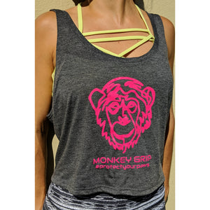 Young lady wearing the Deceitful Strength Monkey Grips pink logo flowy tank crop top shirt